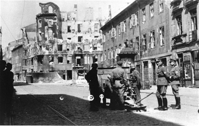 A German gun crew prepares to shell the ruins of a building during the suppression of the Warsaw ghetto uprising